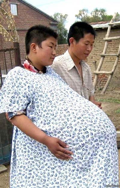 Большой живот беременной женщины на желтом фоне Боке