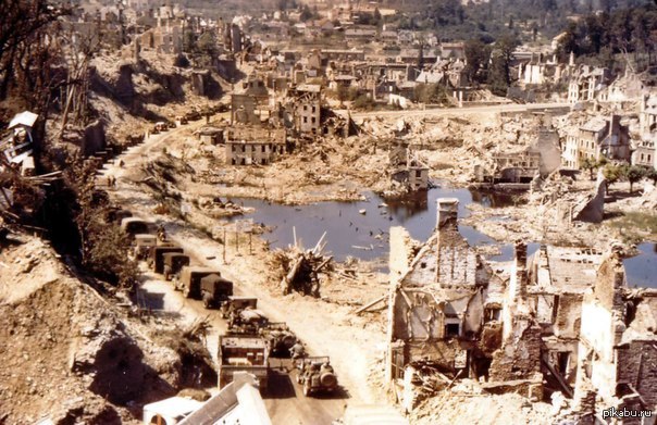 Колонна союзников проезжает через разрушенный французский город Сен-Ло.